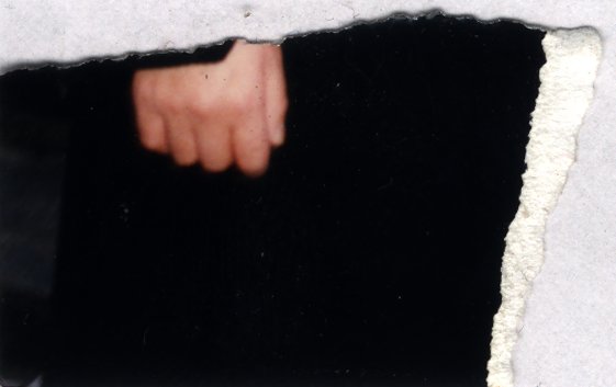 Gros plan d'un poing fermé. Fragment déchiré.ᴬᴵ