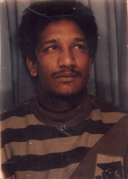 Face of mustachioed man and striped sweatshirt.