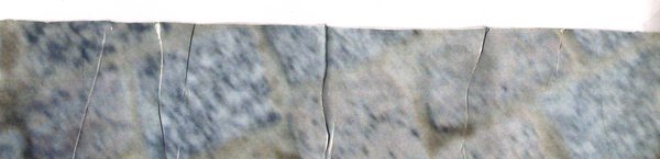 Gros plan sur une surface de pierre craquelée gris-bleu.ᴬᴵ