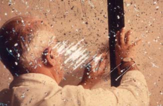 Homme de dos à cheveux blancs trace un trait avec une règle sur un mur.
