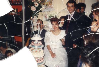 Marié et mariée en blanc devant une pièce montée posée sur une table. Image déchirée en partie reconstituée.