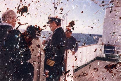 Pont d’un bateau avec homme en uniforme naval et passagers. Image avec rayures.