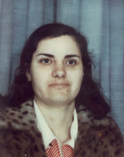 Visage de femme brune souriante.