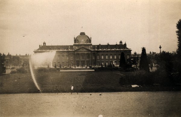 Grand bâtiment ancien vu depuis un parc, au bord d'un bassin. Noir et blanc.ᴬᴵ