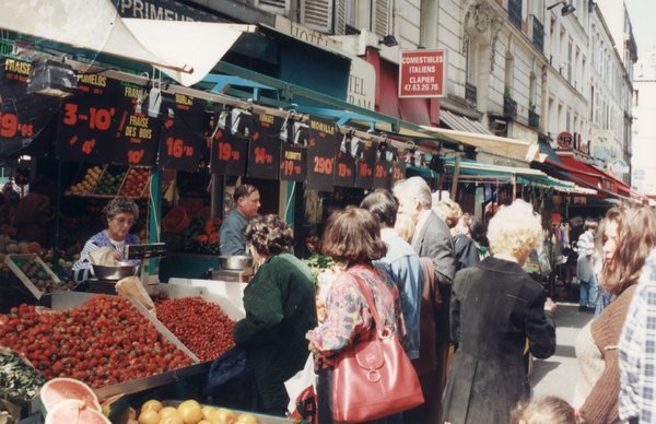 Marché découvert avec passants.
