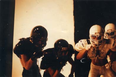 Joueurs de football américain avec casques devant un fond de studio.ᴬᴵ