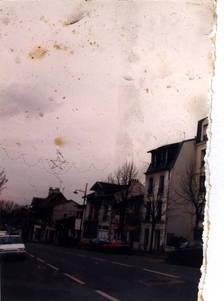 Rue avec façades d’immeubles. Image déchirée.