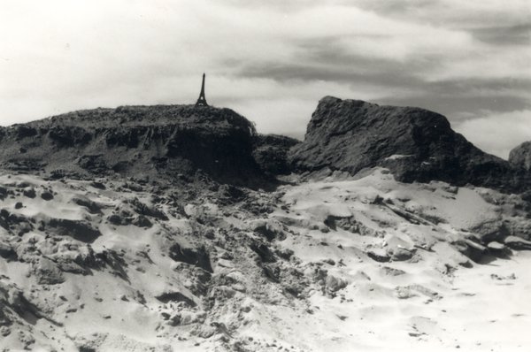 Rochers et dunes de sable, antenne en arrière-plan. Noir et blanc.