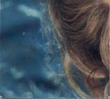 Gros plan sur des cheveux devant un fond bleu. Fragment très abîmé.ᴬᴵ