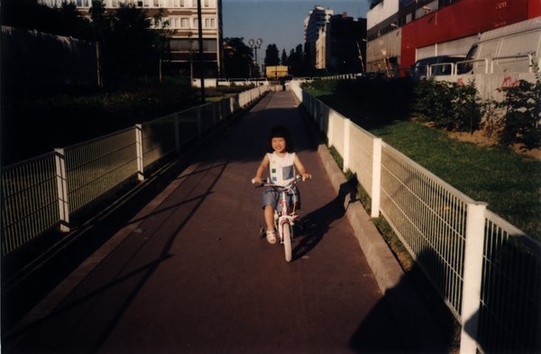 Petite fille à vélo sur une passerelle.