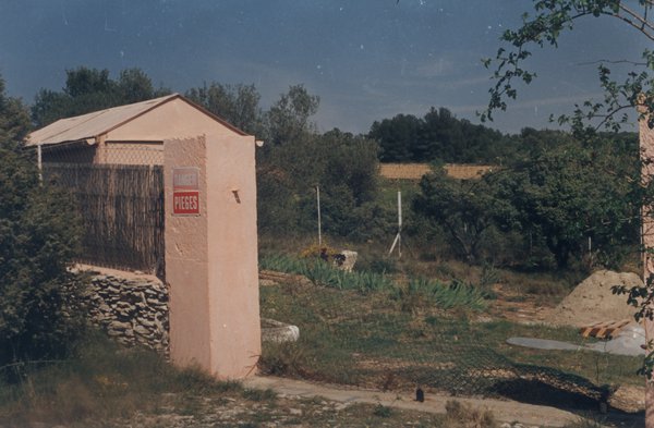 Entrée d’une maison avec poteaux peints en rose.