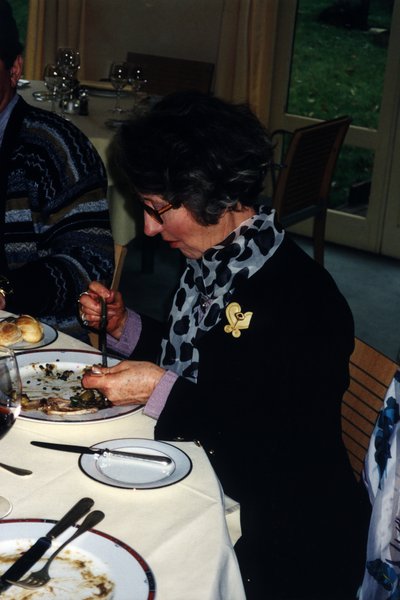 Femme à lunettes devant une assiette en train de manger.