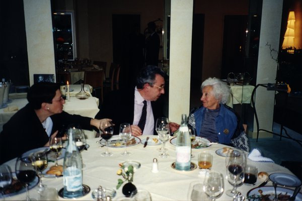 Homme et femmes autour d’une table avec des restes de repas.
