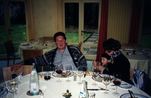 Un homme, une femme et un enfant autour d’une table avec des restes de repas.