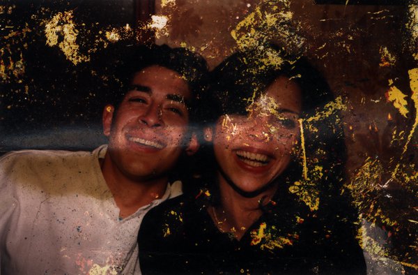 Visage d’un couple, homme et femme, souriant. Image abîmée.