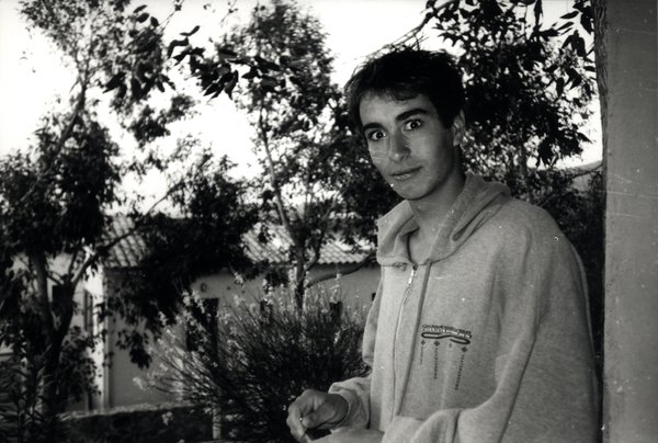 Portrait d'un jeune homme en extérieur devant des arbres. Noir et blanc.ᴬᴵ