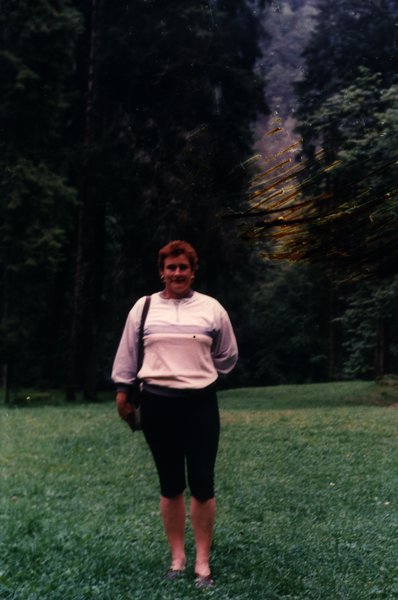 Femme debout dans une clairière entourée d'arbres.ᴬᴵ