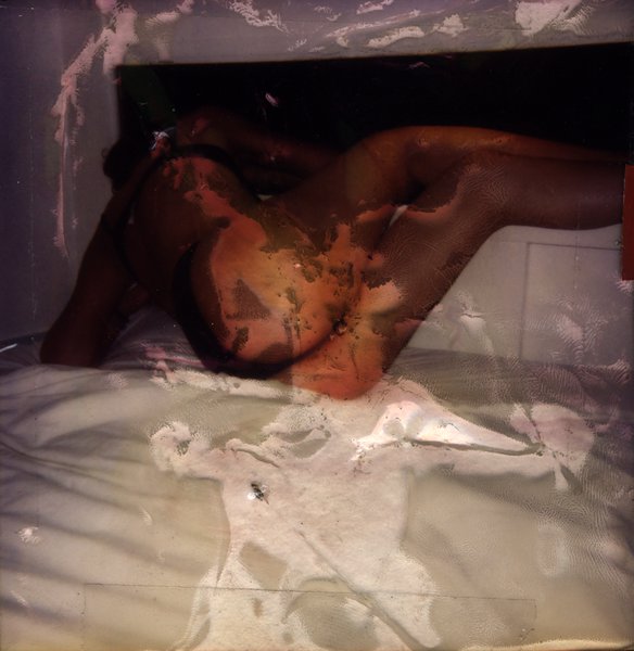 Personne allongée sur un lit. Image très abîmée.ᴬᴵ