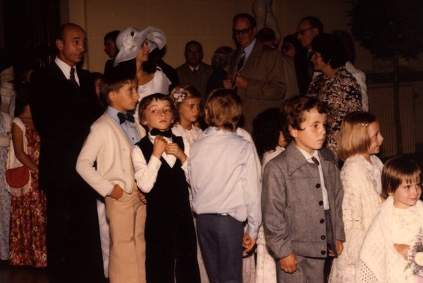 Groupe d'enfants et d'hommes en costume à l'intérieur.ᴬᴵ