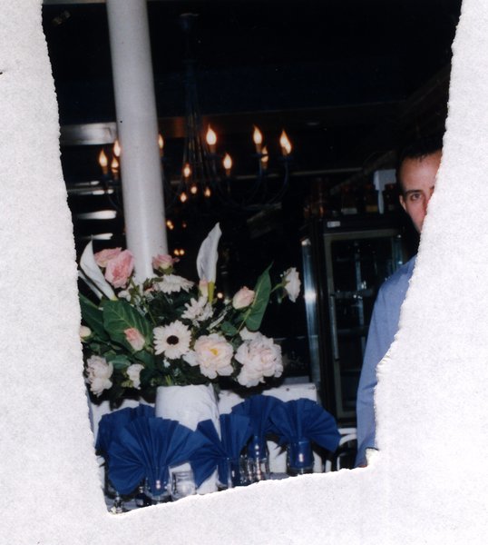 Bouquet de fleurs sur une table dressée dans un restaurant. Fragment déchiré.ᴬᴵ