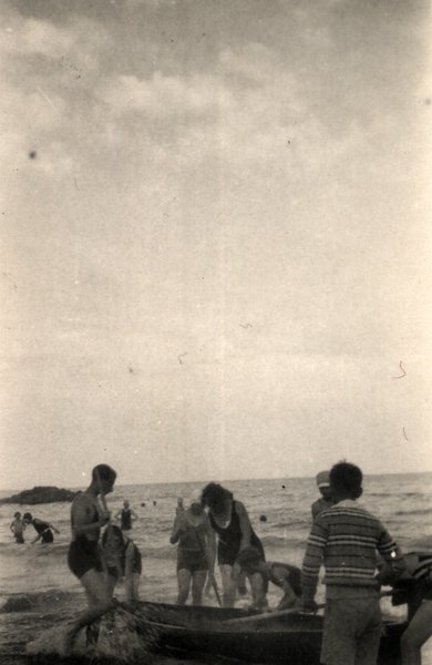 Personnes en maillot de bain ancien près d'une barque sur la plage. Noir et blanc.ᴬᴵ