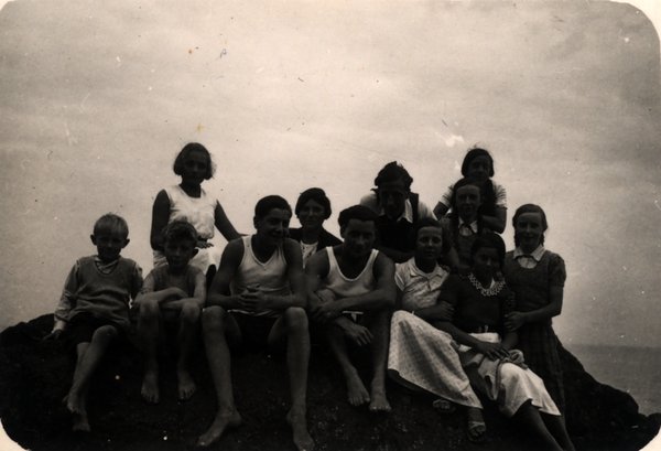 Groupe de personnes posant sur un rocher au bord de la mer. Noir et blanc.ᴬᴵ