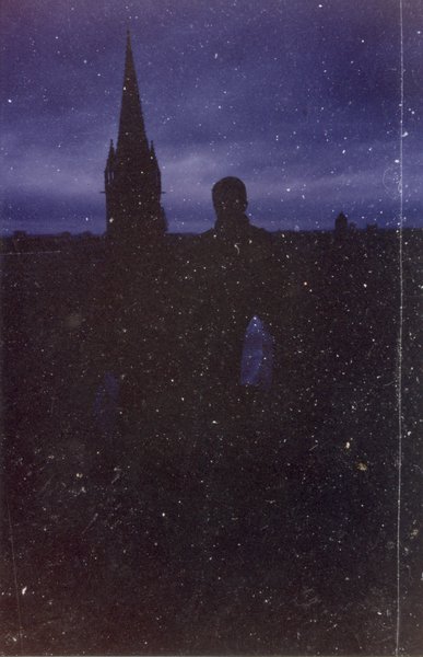 Silhouette d'un clocher d'église sur un ciel nocturne, photo très grainée.ᴬᴵ