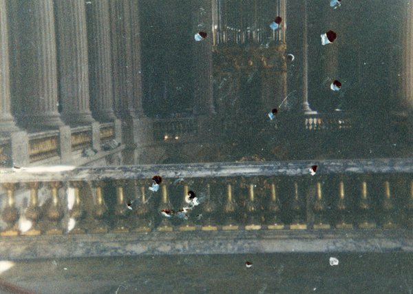 Balustrade en stuc doré et colonnes en marbres sur une coursive.