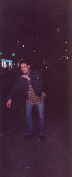 Jeune homme debout dans la rue de nuit.