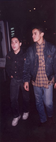 Deux jeunes hommes marchent dans la rue.