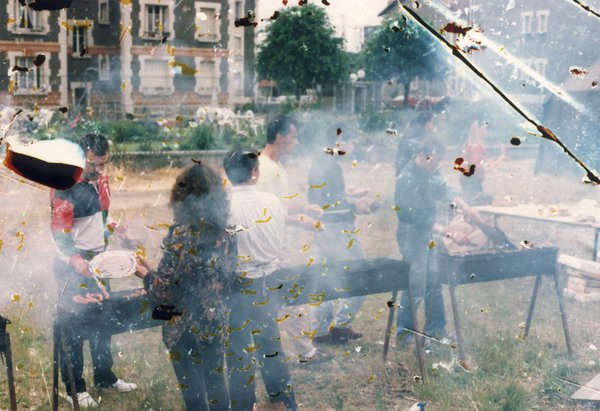 Hommes et femmes debout devant des barbecues.