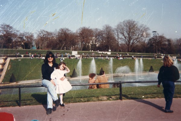 Une femme pose avec une petite fille devant les jets d’eau des jardins du Trocadéro.