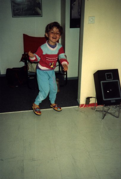 Enfant en pyjama dansant dans un salon.ᴬᴵ