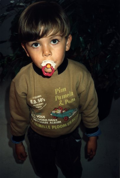 Enfant à la tétine en sweat marron.ᴬᴵ