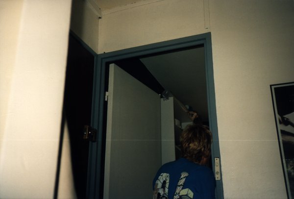Personne de dos entrant dans une pièce, en t-shirt bleu.ᴬᴵ