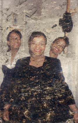 Trois femmes souriantes. Image très rayée et abîmée.ᴬᴵ