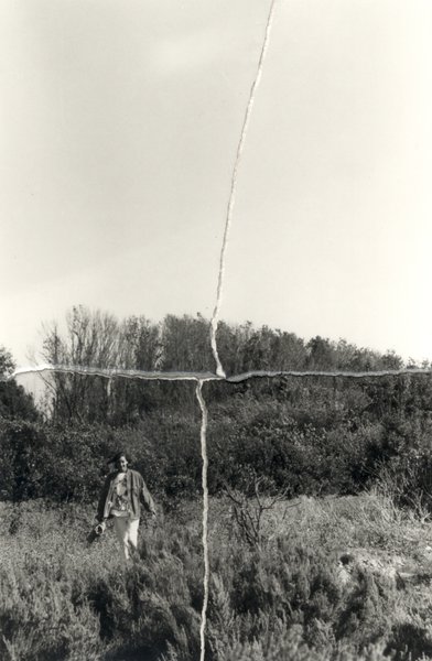 Individu marchant dans les herbes hautes. Image déchirée reconstituée. Noir et blanc.
