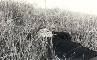 Homme allongé dans de grandes herbes. Image déchirée reconstituée. Noir et blanc.