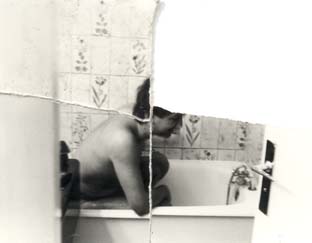 Homme moustachu assis nu dans une baignoire. Image déchirée en partie reconstituée. Noir et blanc.