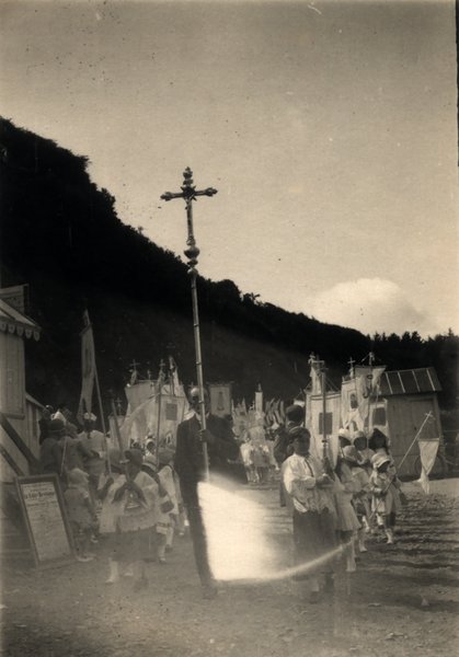 Procession religieuse avec croix devant des cabines de plage, halo de lumière. Photo ancienne sépia.ᴬᴵ