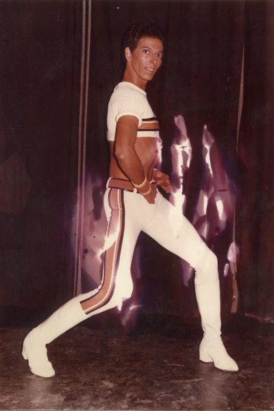 Danseur de revue posant en fuseau blanc et top collant.
