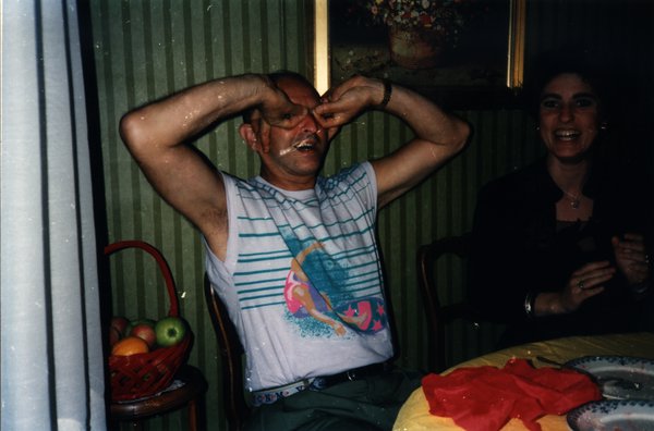 Homme faisant une grimace comique le visage barbouillé, une femme rit à côté.ᴬᴵ