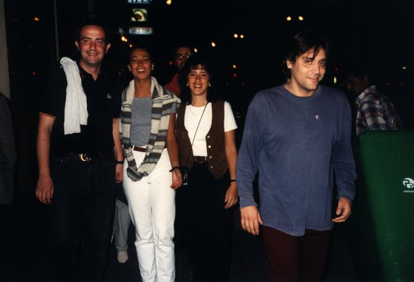 Quatre personnes marchant ensemble dans une rue de nuit.ᴬᴵ