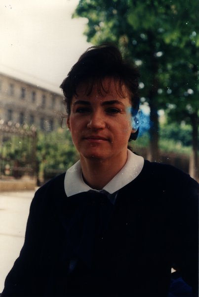 Portrait d'une femme en tenue marine à col blanc dans un parc.ᴬᴵ