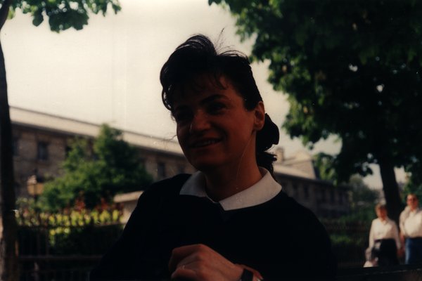 Femme souriante en tenue marine sous un arbre.ᴬᴵ