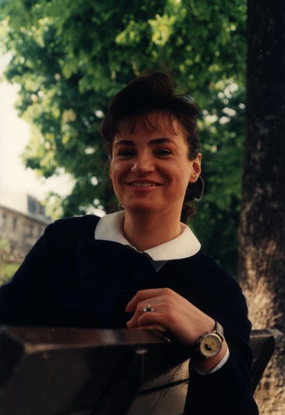 Femme souriante en tenue marine assise sur un banc.ᴬᴵ