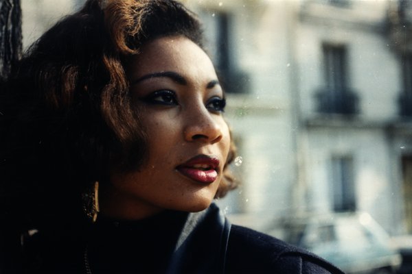 Portrait d'une femme aux cheveux bouclés regardant au loin.ᴬᴵ