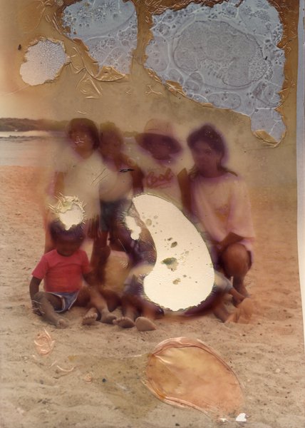 Groupe d’enfants accompagné d’une femme pose sur le sable.