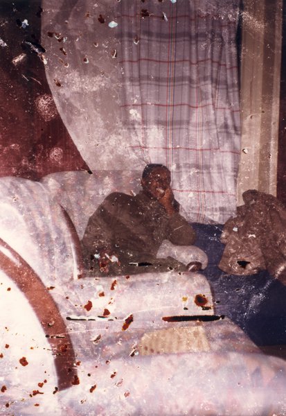 Homme riant assis dans un fauteuil.