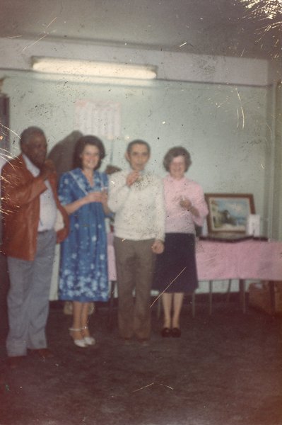 Quatre hommes et femmes debout lèvent leurs verres.